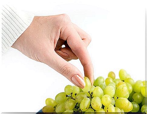 Woman picking grapes that are good natural diuretics