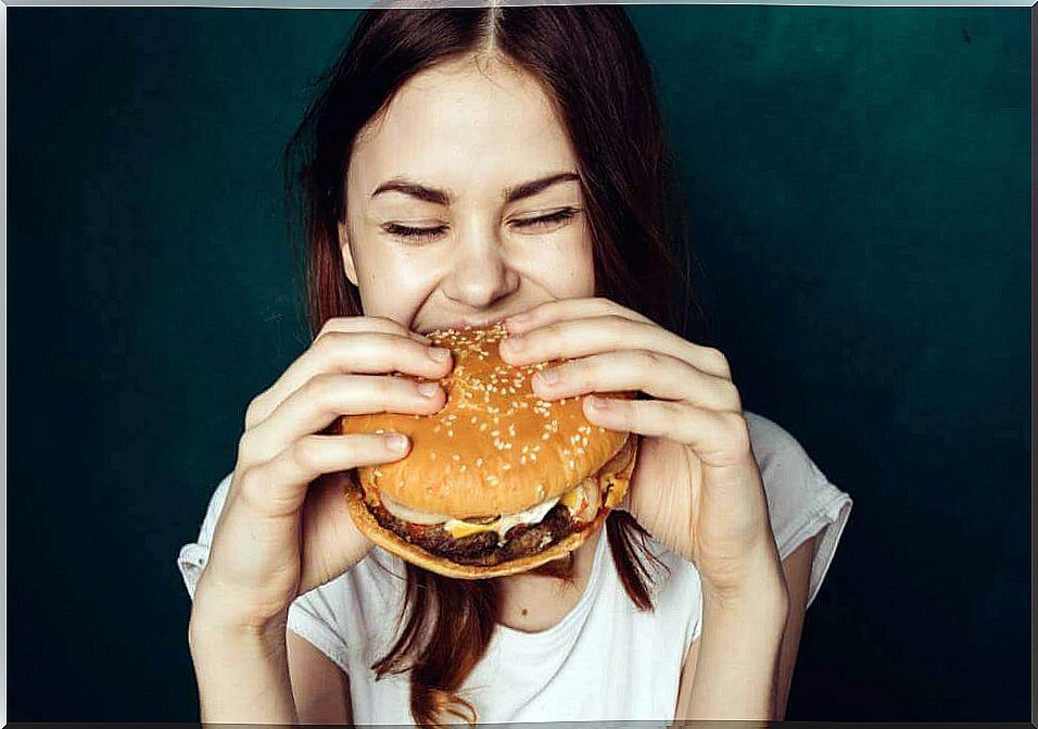 Woman eating a hamburger.